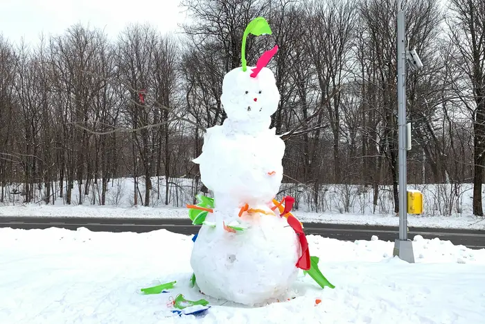 A snowman made with bright plastic bits of broken sleds as seen in Prospect Park.